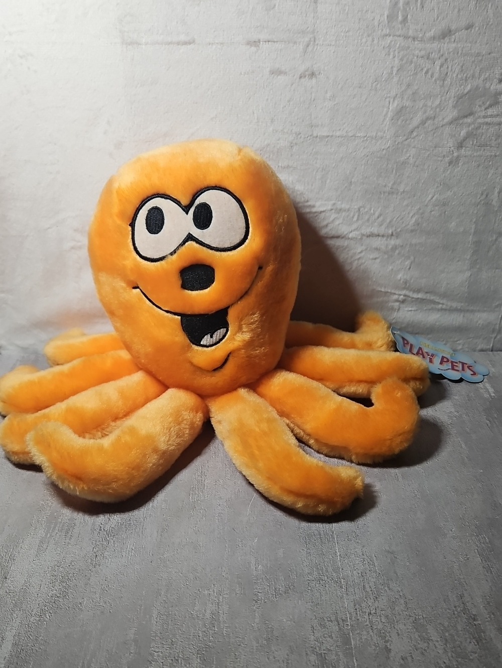 Vintage vibrant orange octopus plush toy featuring cartoonish googly Eyes